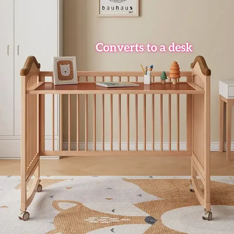Multi-functional wooden baby crib converted into a kids study writing desk with books and decor.