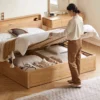 Woman easily lifting hydraulic gas lift bed frame revealing spacious under-bed storage compartment for bedding and organizers.