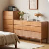 manna-cherry-wood-5-drawer-and-9-drawer-dressers-bedroom Manna cherry wood 5-drawer tall dresser and 9-drawer wide dresser styled side-by-side in a cozy bedroom.