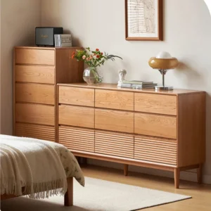 Manna cherry wood 5-drawer tall dresser and 9-drawer wide dresser styled side-by-side in a cozy bedroom.