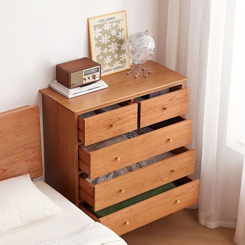 manna-cherry-wood-5-drawer-dresser-open-drawers-storage Side angle view of Manna cherry wood 5-drawer dresser with all drawers pulled open showing organized clothing storage beside a bed.