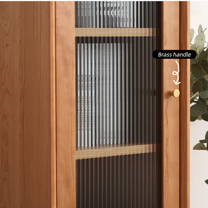 Close-up detail of fluted glass door with a solid brass knob handle on Manna cherry wood cabinet.