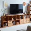 Manna cherry wood modular bookcase used as a low TV stand with storage cubes and drawers in a bright living room.