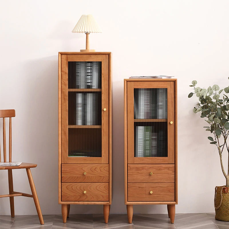 Manna cherry wood narrow fluted glass cabinets in 110cm and 130cm heights placed side-by-side in a room with a wooden chair.