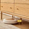 Close-up view showing 15cm tapered leg clearance on Manna oak dresser allowing a robot vacuum to clean underneath.