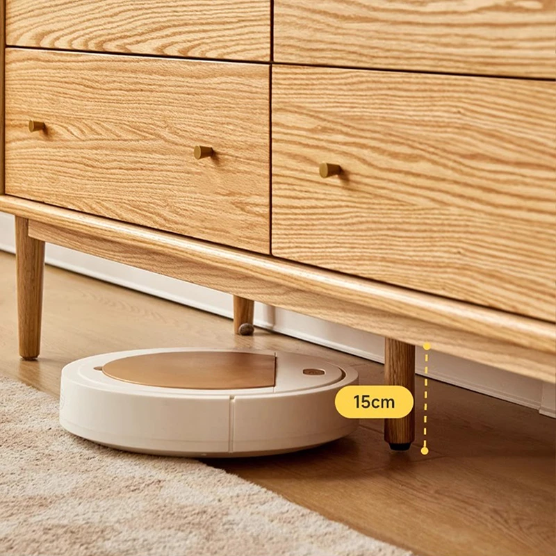 Close-up view showing 15cm tapered leg clearance on Manna oak dresser allowing a robot vacuum to clean underneath.