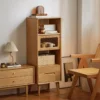manna-oak-narrow-accent-cabinet-bedroom-sideboard Manna oak narrow accent cabinet placed next to a bedroom sideboard dresser and a rattan chair.
