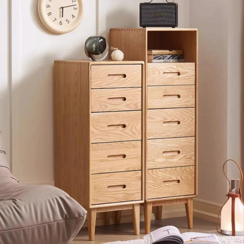 Manna oak narrow 5-drawer chest and tall narrow chest with open top shelf styled side-by-side in a cozy room corner.