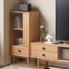 Manna oak narrow fluted glass cabinet styled next to a wooden TV console in a living room corner showing compact floor space usage.