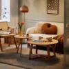 Manna oak round side table paired with a matching wooden coffee table in a modern cream living room with a white sofa.