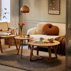 Manna oak round side table paired with a matching wooden coffee table in a modern cream living room with a white sofa.
