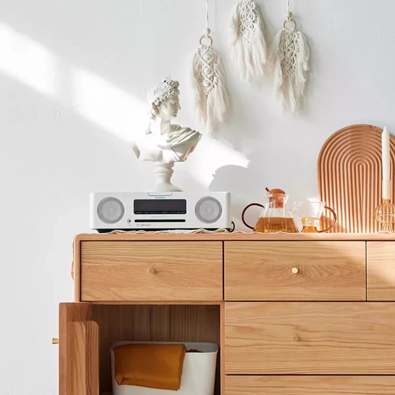 Close-up view of solid brass knob handles and natural oak wood grain on Manna sideboard credenza tabletop with CD player.