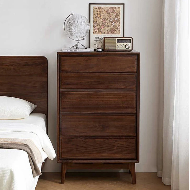 manna-walnut-5-drawer-tall-chest-bedroom-front-view Front view of Manna black walnut 5-drawer tall chest placed next to a bed in a warm bedroom.