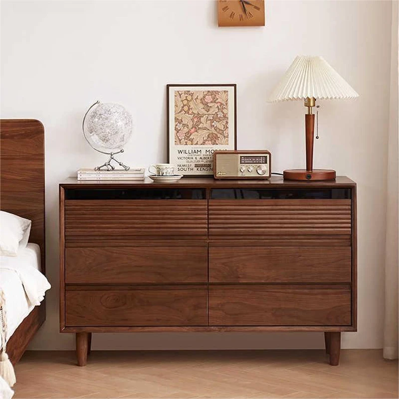 Front view of Manna black walnut 6-drawer dresser with fluted top drawers placed next to a bed as a bedroom storage cabinet.