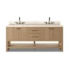 Natural light oak double sink vanity cabinet with white marble top, bronze hardware handles, and open bottom storage shelf.