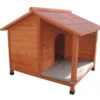 Large outdoor solid wood dog house with extended porch deck, asphalt roof, and golden retriever sleeping on cushion.