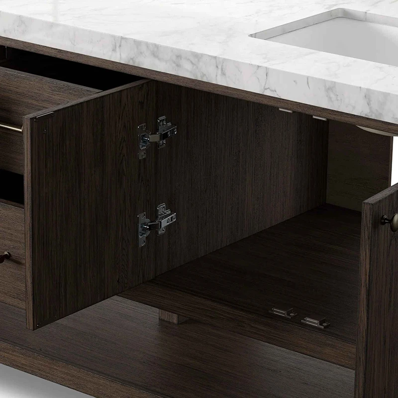 Interior storage view of open bathroom vanity door showing concealed soft-close metal hinges and undermount ceramic basin.
