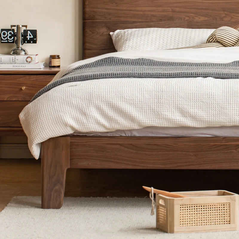solid-walnut-bed-frame-corner-and-nightstand Crafted solid black walnut bed foot and side rail detail paired with a matching wooden nightstand.