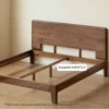 solid-wood-bed-headboard-storage-ledge-detail Close-up of solid walnut wood headboard featuring a rounded top ledge for resting glasses and small essentials.