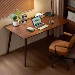 Dark wood study computer desk with laptop, green potted plant, and ergonomic leather chair in a cozy home office.