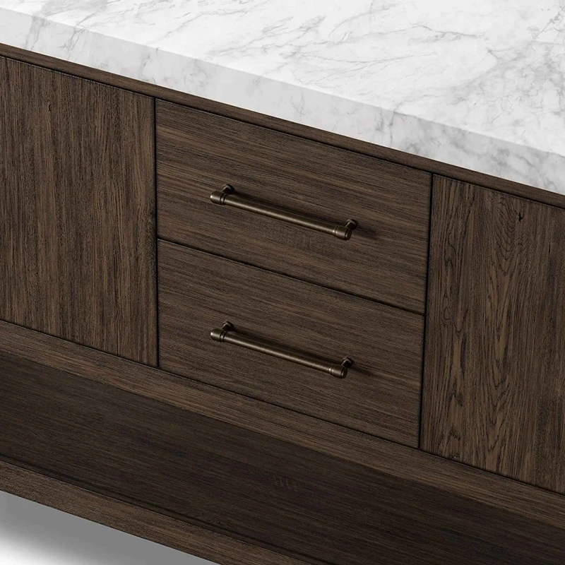 Close-up of solid wood center vanity drawers with textured wood grain and vintage bronze bar handles.