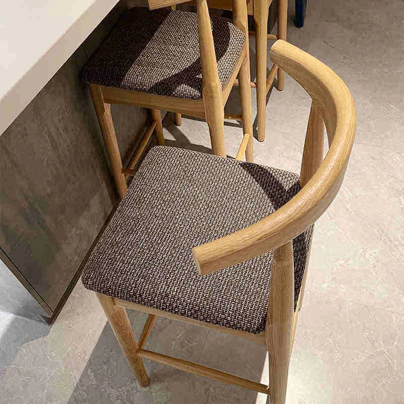 manna-oak-bar-stool-woven-seat-detail Close up detail of oak bar stool woven brown seat and curved backrest beside a kitchen island under construction.
