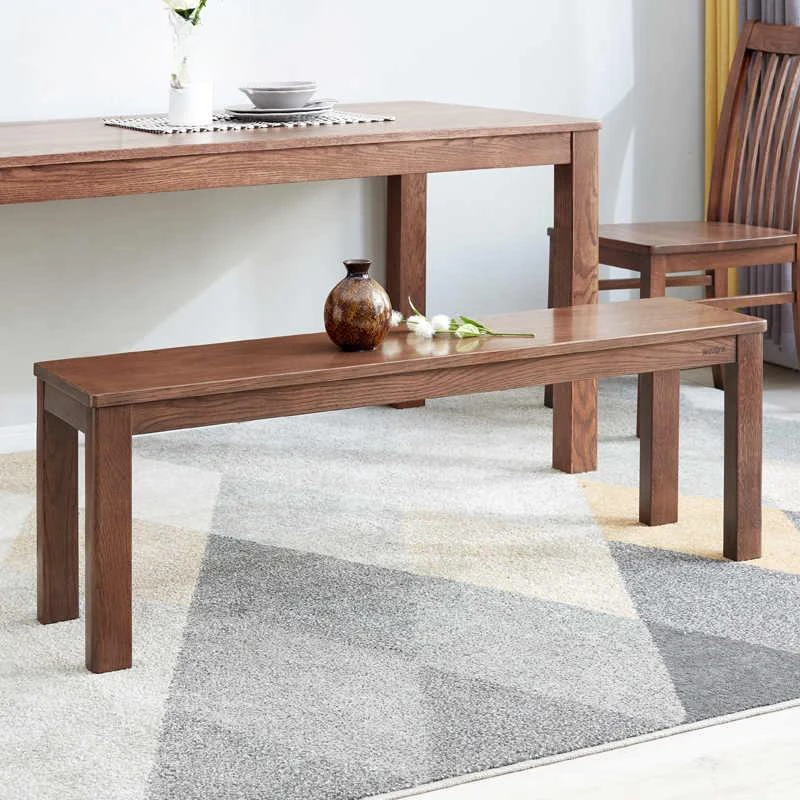 manna-oak-dining-bench-dining-room-cd1003 Brown oak dining bench with square legs set under a matching oak dining table on a geometric grey rug.