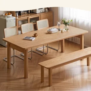 Light oak dining bench paired with a rattan chair dining set under a table in a bright herringbone floored room.