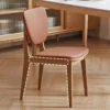 Detail view of an oak dining chair with a brown leather seat and backrest showing the frame outline in white dashes.