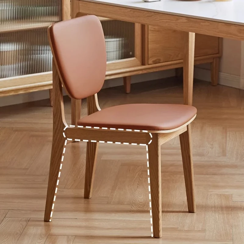 Detail view of an oak dining chair with a brown leather seat and backrest showing the frame outline in white dashes.
