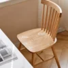 Main view of solid oak dining chair with spindle back and wooden seat near a white table with 42cm and 37.5cm overlays.