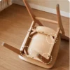 Detail view of the underside of an oak dining chair showing the solid wood seat frame and leg joint construction.