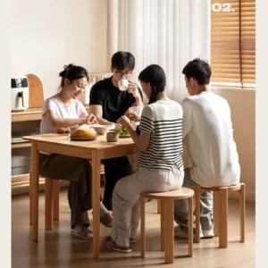manna-oak-dining-stool-dining-room Family of four dining at a solid wood table while seated on light oak round stacking stools in a bright room.