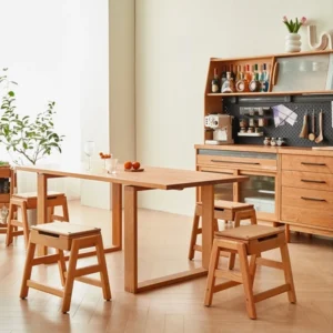 manna-oak-folding-step-stool-dining-room Lifestyle view of oak folding step stools with hinged seats and storage placed around a wooden dining table in a kitchen.