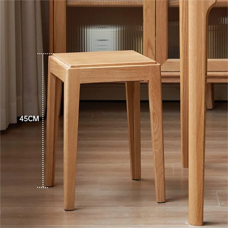 manna-oak-stool-lifestyle Solid oak square stool with a 45cm height marker standing on wood flooring beside a wooden cabinet and table.