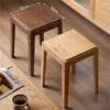manna-oak-stool-size-guide Size guide showing two stackable square stools in walnut and oak finish with 32cm seat tops on a wooden floor.