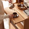 manna-oak-tall-sideboard-coffee-bar-lifestyle Lifestyle view of an oak tall sideboard coffee bar with a gooseneck kettle pouring into a metal cup on the pull-out shelf.