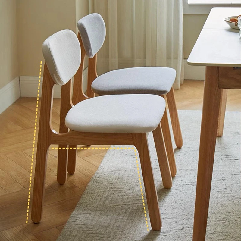 manna-oak-upholstered-dining-chair-back-view Back view of two oak dining chairs with grey upholstered cushions showing the angled tapered rear legs.