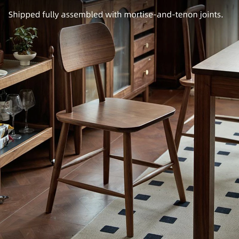 manna-walnut-dining-chair-assembly Walnut dining chair shown fully assembled with mortise and tenon joints in a dining room with a sideboard and rug.
