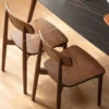 Top view detail of two walnut dining chairs showing the rounded solid wood seat with a 45cm seat depth dimension overlay.