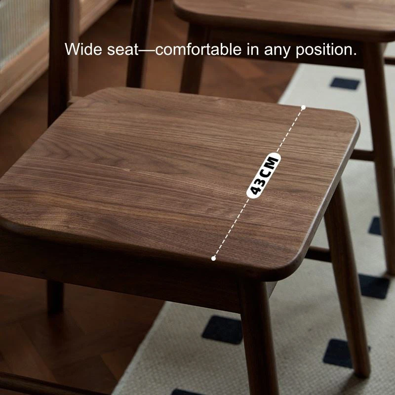 Detail view of the wide walnut dining chair seat showing a 43cm seat depth measurement on visible wood grain.