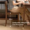 manna-walnut-dining-chair-seat-dimensions-cy1009 Angled view of a walnut dining chair with a person seated, showing a 44cm seat height measurement overlay.