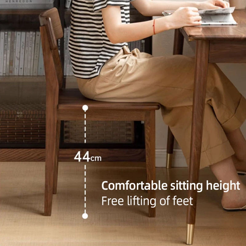manna-walnut-dining-chair-seat-dimensions-cy1009 Angled view of a walnut dining chair with a person seated, showing a 44cm seat height measurement overlay.