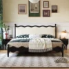 Black bed with cream wavy upholstered headboard in a front view shot