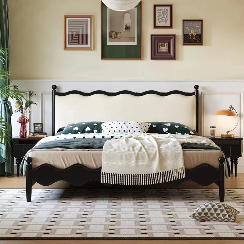 Black bed with cream wavy upholstered headboard in a front view shot