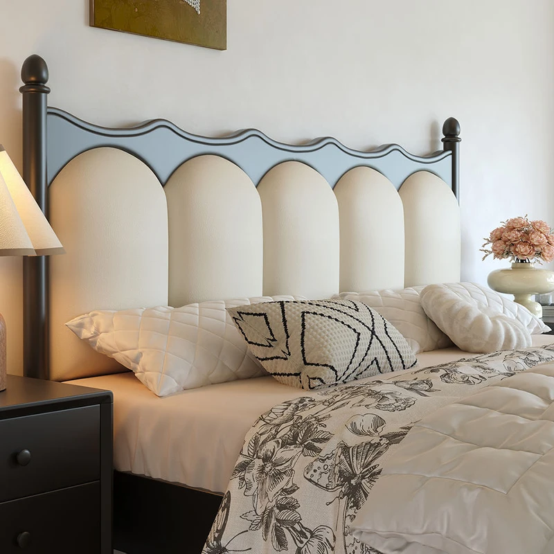 Black headboard with arched cream upholstered panels closeup detail