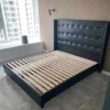 Black leather bed frame with slatted base shown from the side view
