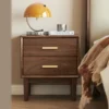 Black walnut two drawer nightstand beside bed with amber mushroom lamp