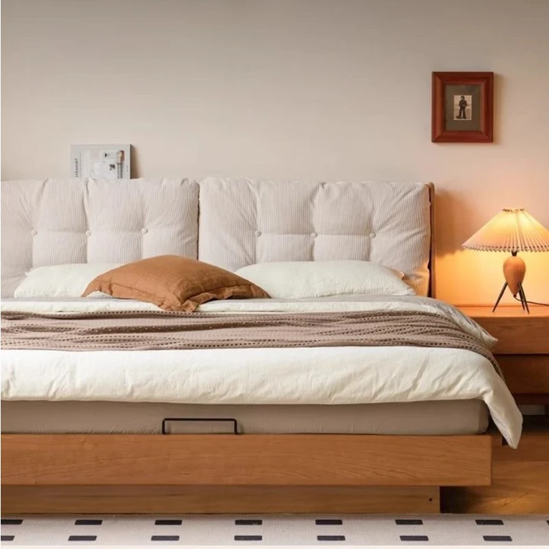 Cherry gas lift storage bed with cushion headboard in a warm bedroom setting