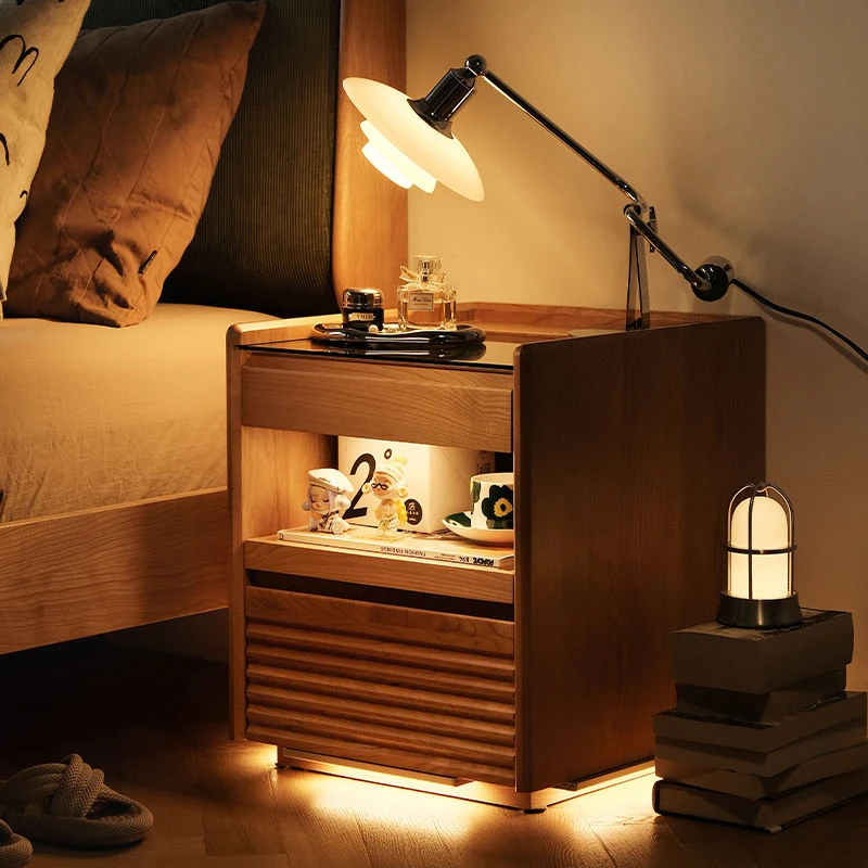 Cherry wood nightstand with built-in LED light glowing in a night bedroom scene